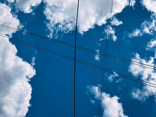 istock Low Angle View of Power Lines and a Bright Blue Sky 2228450744