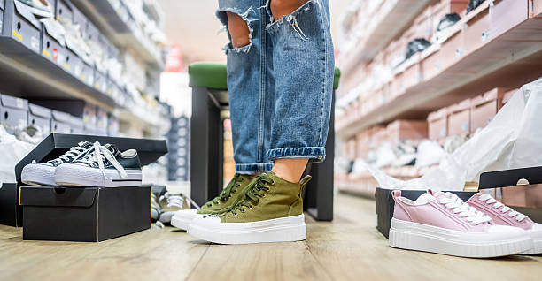 istock Woman Trying On Sneakers In Different Colors 2228453013