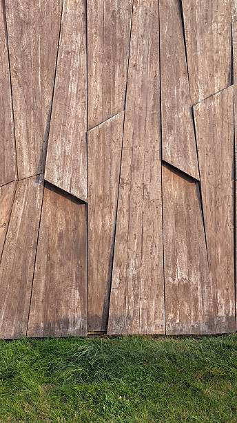 istock Intriguing Abstract Wooden Panel Design Complemented by a Lush Grass Background Setting 2228454025