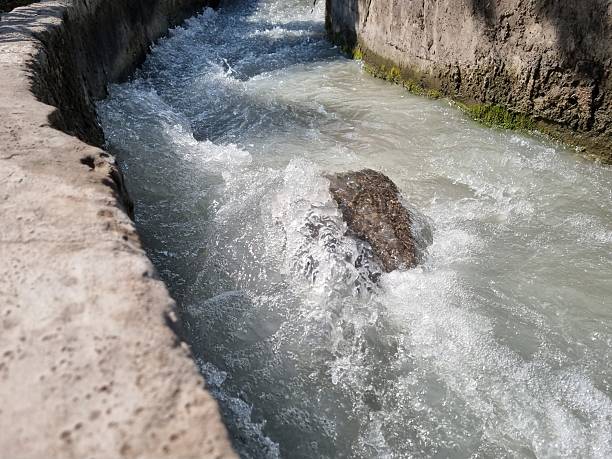 A large rock in a channel with running water