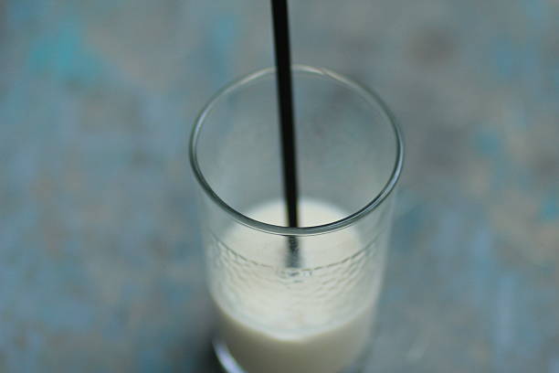 a glass of milk with a straw in it
