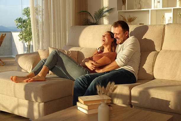 Happy couple at home with the man tickling woman stock photo