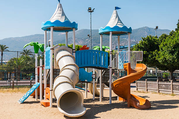 istock A vibrant playground features colorful slides and climbing structures amidst sandy ground, perfect for children to play in a sunny park setting surrounded by trees 2228456304