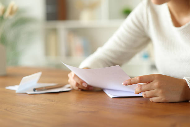 Woman hands holding and reading letter at home stock photo