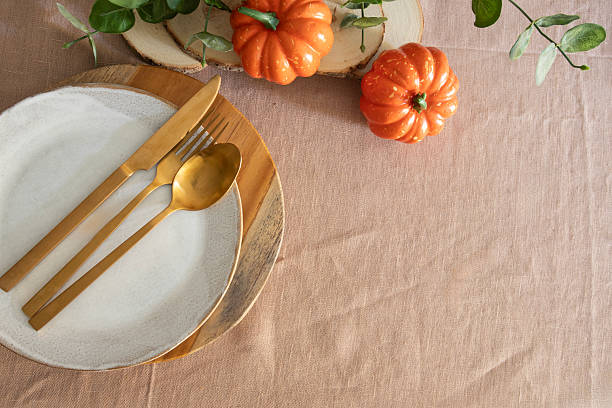 istock Minimalist Thanksgiving table setting, rustic plate napkin, gold cutlery and autumn pumpkin decoration on linen blackguard, copy space 2228457501
