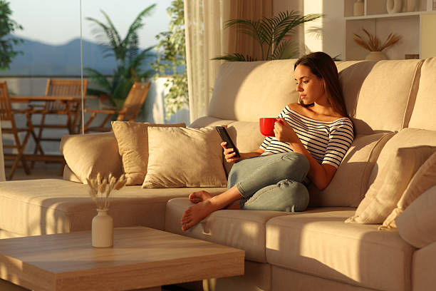 istock Relaxed woman drinking coffee from red cup using cell phone 2228457577