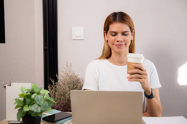 istock Happiness young caucasian businesswoman drinking coffee while working on laptop computer in home office, happy business woman drinking beverage while using laptop for relax, business concept. 2228458987
