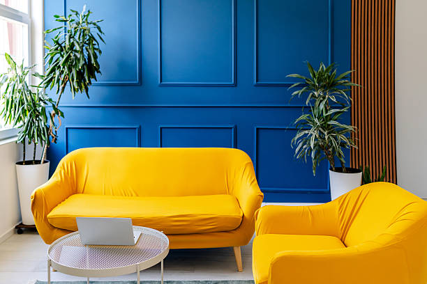 istock Brightly colored yellow sofas create a sunny ambiance in a modern indoor space with greenery 2228461836