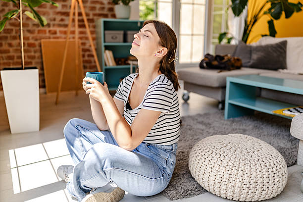 istock Young woman enjoying a warm drink while relaxing indoors in a cozy setting during daylight hours 2228463204