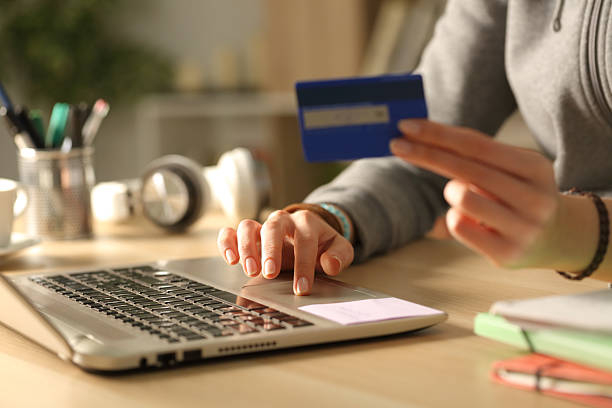 istock Student hands paying online in the night at home 2228468488