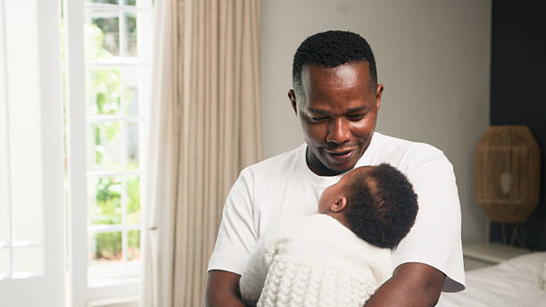 istock Loving Father Cuddling Young Baby in a Bright and Peaceful Home Interior Setting 2228469248