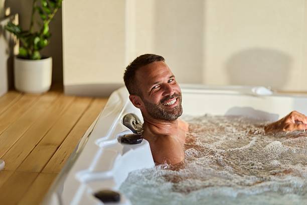 istock Smiling Man Relaxing in a Bubbling Hot Tub Spa Indoors 2228469906