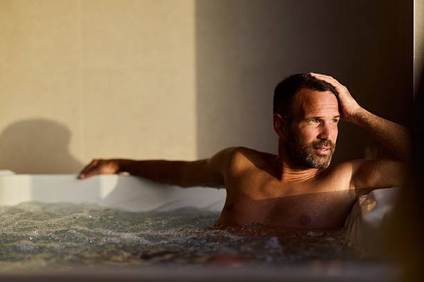 istock Relaxed Man Sitting in a hot tub with a Calm and Thoughtful Expression 2228469907