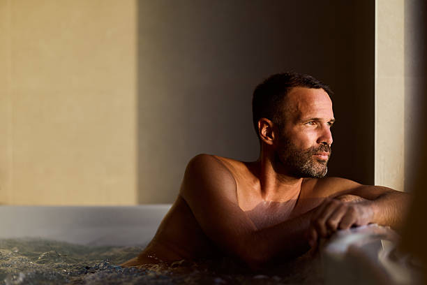 Man Relaxing in a hot tub Contemplating While Enjoying Warm Sunlight