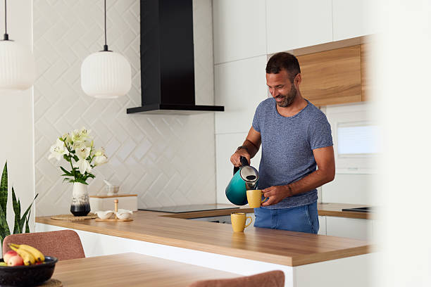 istock Man Preparing Coffee in a Modern Kitchen Setting With Warm Contemporary Design 2228469930