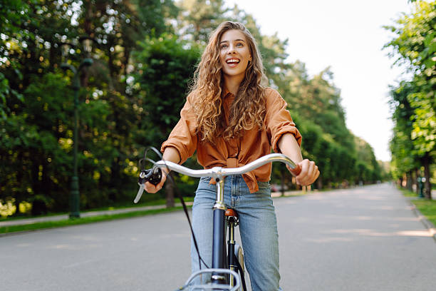 istock Cheerful woman with a bicycle in a sunny park. 2228471014
