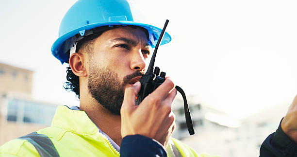 istock Construction site, radio and man with engineering, talking and inspection with conversation. Helmet, outdoor and person with architecture, project management and property renovation with safety check 2228476348