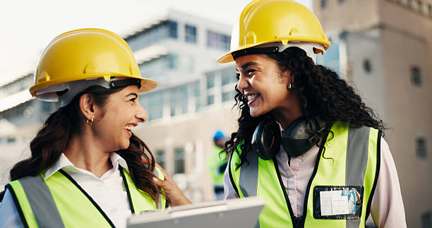 istock Team, clipboard and engineer with women on rooftop for building inspection, checklist or chat. Safety regulations, architecture report and collaboration with people on construction site for blueprint 2228476457
