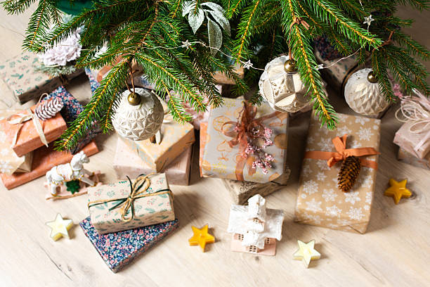 istock Beautifully wrapped gift boxes in natural colors sit neatly under a Christmas tree adorned with ornaments, creating a warm and serene holiday vibe 2228478439