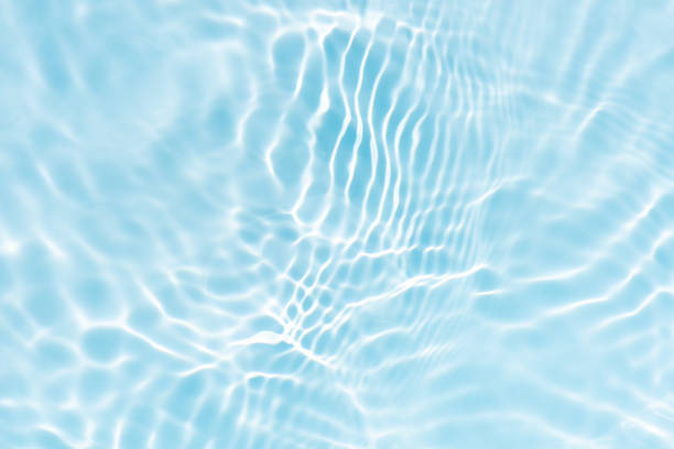 istock Blue water with ripples on the surface. Defocus blurred transparent blue colored clear calm water surface texture with splashes and bubbles. Water waves with shining pattern texture background. 2228479053