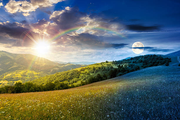 istock mountain landscape with wide meadow on summer solstice with sun and moon 2228479554