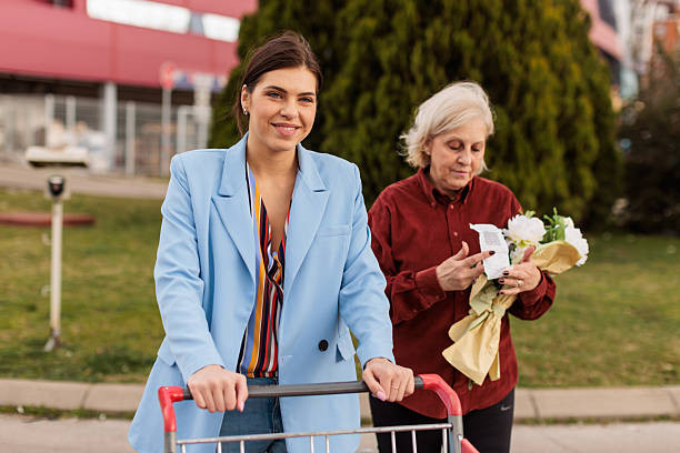 istock Mother Checking Shopping List While Daughter Pushes Grocery Cart 2228482843