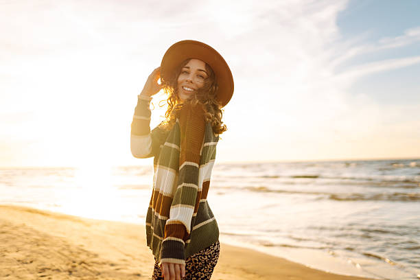 istock Joyful woman in hat having fun and walking on sunny beach. 2228483563