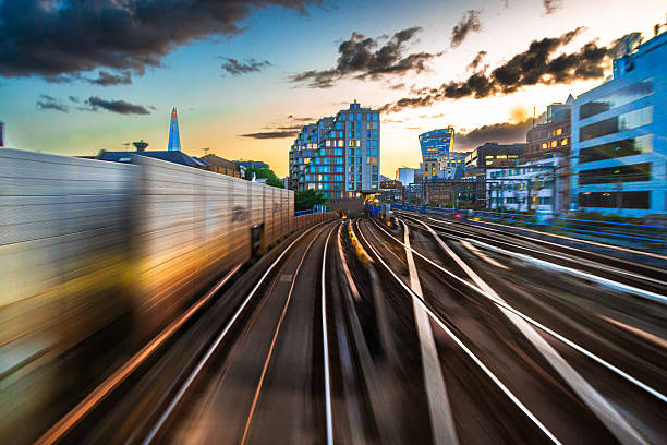 Long exposure shot depicting the blurred motion of railroad tracks as viewed from a passenger train as it speeds through the city.