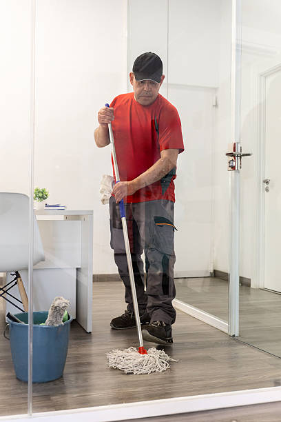 Janitor mopping the floor in a modern office