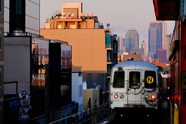 Queens, New York, USA- August 2, 2025: An elevated subway train makes its way through a cinematic and futuristic Queens cityscape with colorful buildings and skyscrapers.