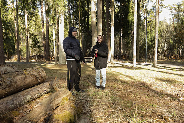 istock Two people dressed in winter jackets standing in the woods, pausing for a warm drink from a thermos, enjoying nature, quiet conversation, and seasonal coziness. 2228493303