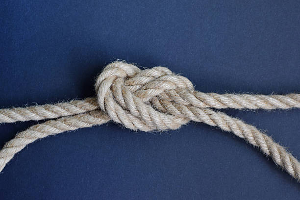 Thick rope knot on blue background. Hemp rope with knot.