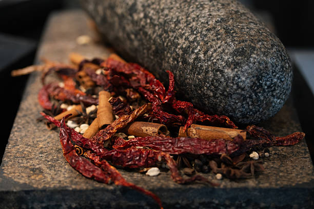 Colorful chili, herbs, and pepper flakes suspended in motion, creating a dynamic culinary explosion. High-resolution macro photo.