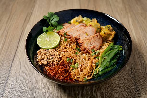 istock Tom yum egg noodles with bbq pork on wooden background 2228498068