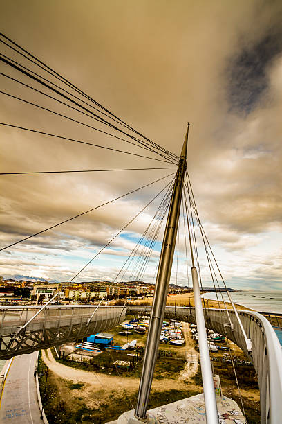 istock Cable-stayed bridge spanning marina with moored boats, cloudy sky backdrop in coastal Pescara, Italy 2228498180
