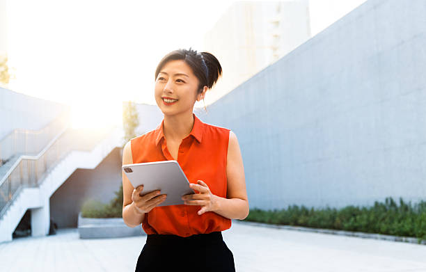 istock Businesswoman using digital tablet outside the office building 2228499445