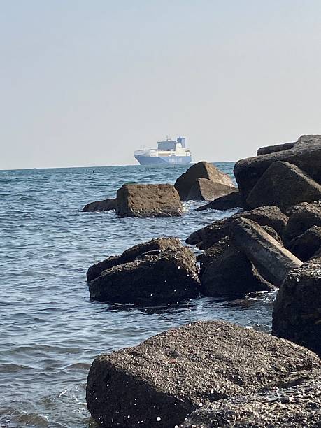 istock Tanker in background with rocks on coast in foreground 2228499471