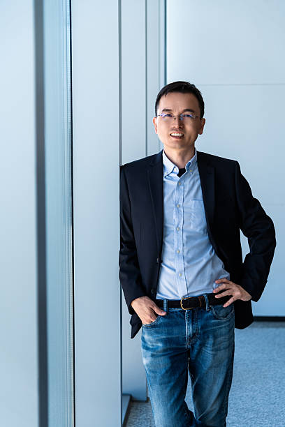 istock Businessman standing in office with hands in pockets 2228499510