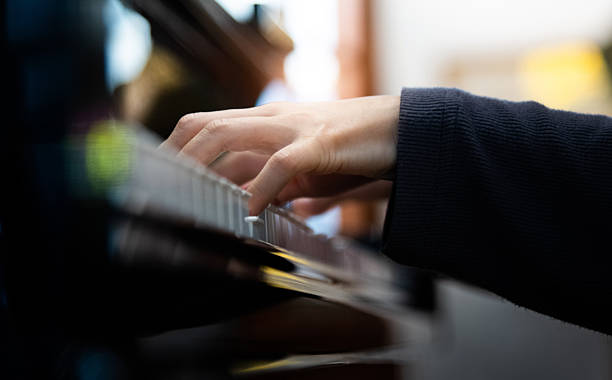 istock Woman hand playing on piano keyboard 2228500620