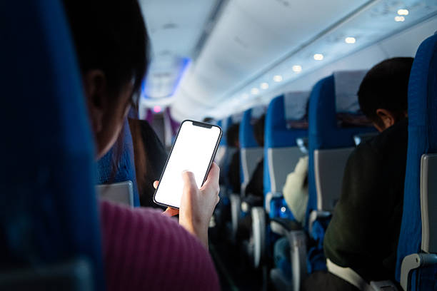 Woman using smart phone on the airplane