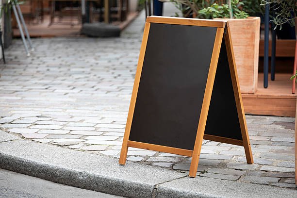 istock Chalkboard A-frame sign with copy space on a cobblestone pavement 2228502069