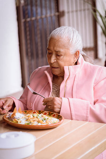 istock Old woman eating chilaquiles 2228502609
