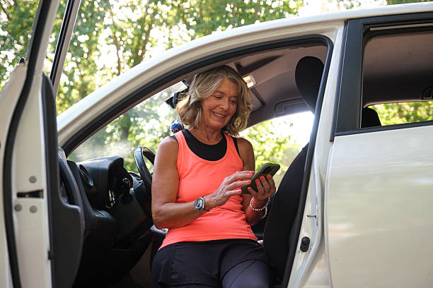 istock Senior sportswoman using mobile phone in car after training 2228504353