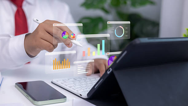 istock Analytics dashboards and floating holographic charts displayed as a person uses a stylus on a tablet. Concept of modern business analysis, financial planning, and data-driven technology. 2228504940