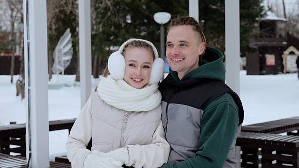 istock Affectionate young couple cuddling inside snow covered park gazebo, wearing warm winter clothing, sharing intimate moment during chilly season, expressing mutual love and joy 2228504997