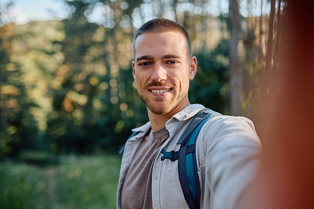 istock Smiling hiker taking selfie portrait while enjoying trekking day in forest 2228510479