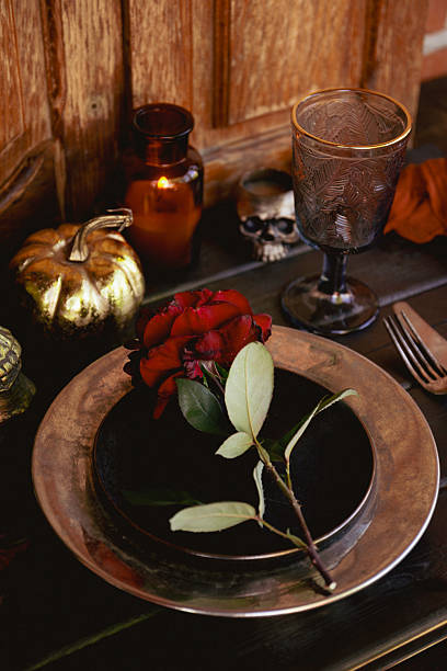 istock Served table with autumn decor, red roses, scull and pumpkin. Halloween dinner table setting 2228510855