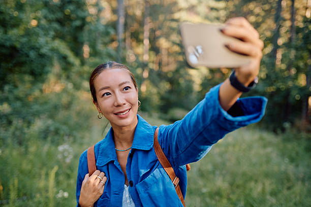 istock Young hiker taking selfie with smartphone in forest during summer trip 2228511174