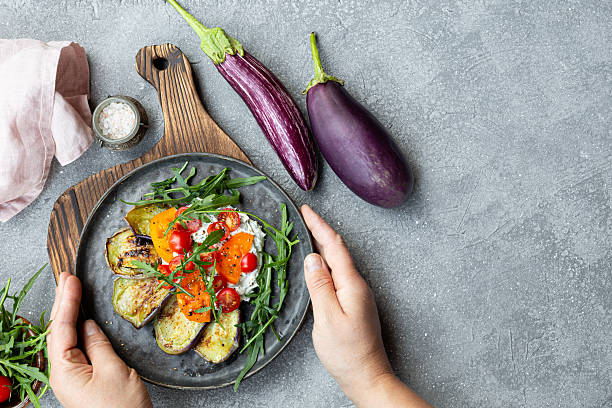 istock Salad with fried eggplant, cream cheese, tomatoes and arugula on grey background top view copy space for text. Vegetarian food 2228511199