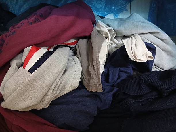 istock Unorganized yellow, white and blue clothes in a wardrobe 2228511505